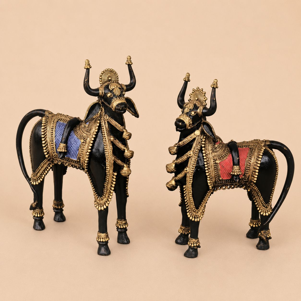 Ornate golden bull figurines on beige background